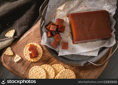 Quince cheese or marmelada is a sweet, thick jelly made of the pulp of the quince fruit. Marmalade in crackers on a kitchen counter. Dulce de membrillo in Spain