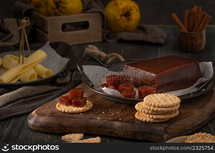Quince cheese or marmelada is a sweet, thick jelly made of the pulp of the quince fruit. Marmalade in crackers on a kitchen counter. Dulce de membrillo in Spain