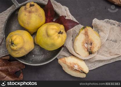 Quince fruits and marmelade in a ceramic bowl on table top