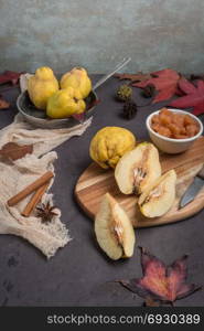 Quince fruits and marmelade in a ceramic bowl on table top