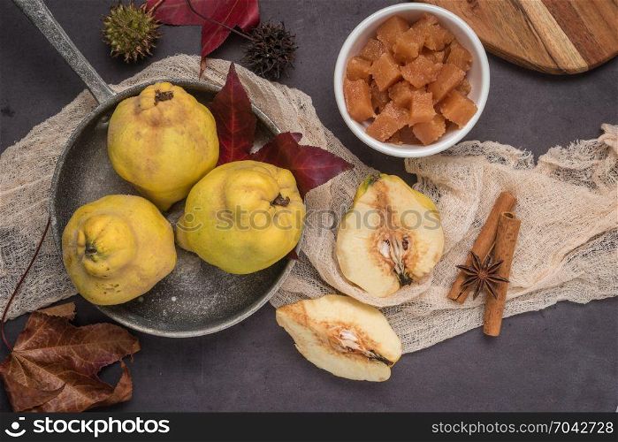 Quince fruits and marmelade in a ceramic bowl on table top