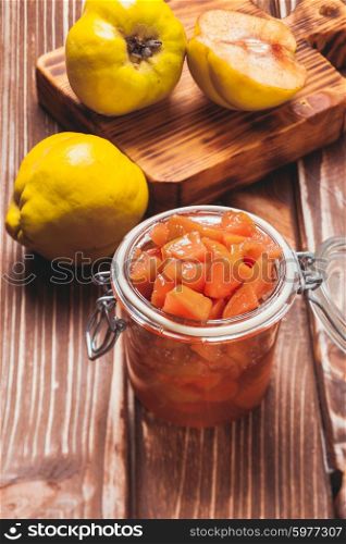 Quince jam in the glass jar and fruits on the background. The Quince jam
