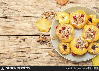 Quince stuffed with raisins and walnuts.Baked quince on old wooden table.Autumn food. Baked quince with raisins