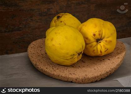 Quinces on a cork tray on a kitchen counter.