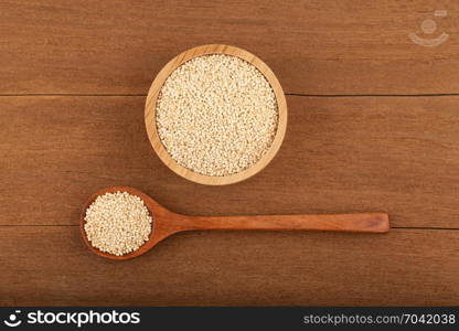 quinoa in wooden bowl on wood background