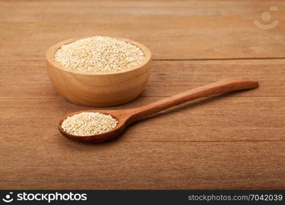 quinoa in wooden bowl on wood background