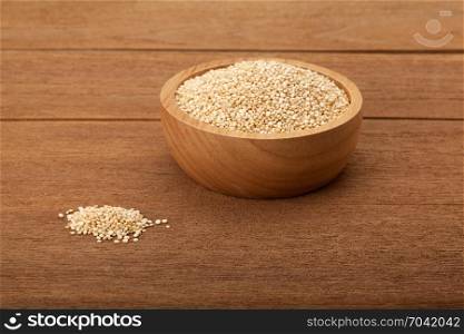 quinoa in wooden bowl on wood background