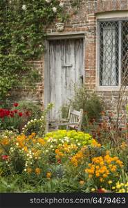 Quintessential vibrant English country garden scene landscape wi. Quintessential English country garden scene landscape with fresh Spring flowers in cottage garden