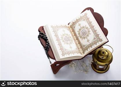 Quran book on table with candle beside