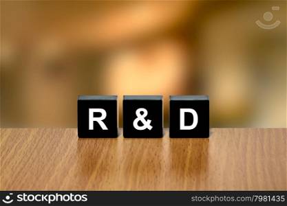 r&amp;d or Research and development on black block with blurred background