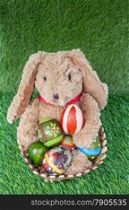 Rabbit, sit and holding colorful eggs in basket on grass for happy easter festival, top view