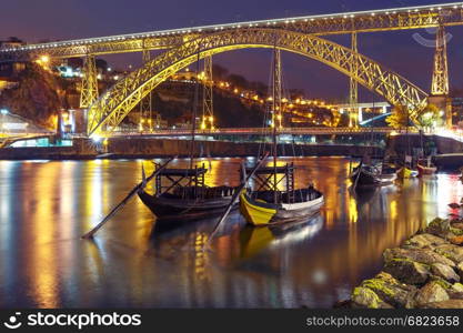 Rabelo boats on the Douro river, Porto, Portugal.. Traditional rabelo boats with barrels of Port wine on the Douro river, Ribeira and Dom Luis I or Luiz I iron bridge on the background, Porto, Portugal.