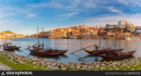 Rabelo boats on the Douro river, Porto, Portugal.. Panoramic view of traditional rabelo boats with barrels of Port wine on the Douro river, Ribeira on the background, Porto, Portugal.