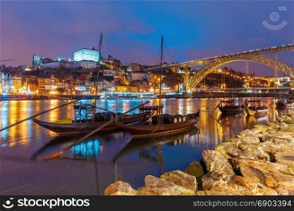 Rabelo boats on the Douro river, Porto, Portugal.. Traditional rabelo boats with barrels of Port wine on the Douro river, Ribeira and Dom Luis I or Luiz I iron bridge on the background, Porto, Portugal.