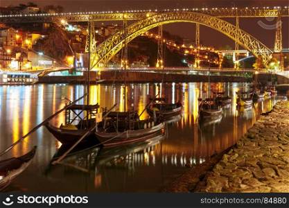 Rabelo boats on the Douro river, Porto, Portugal.. Traditional rabelo boats with barrels of Port wine on the Douro river, Ribeira and Dom Luis I or Luiz I iron bridge on the background, Porto, Portugal.
