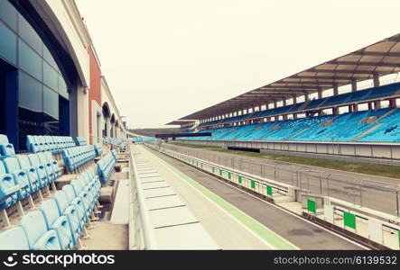 racing, motosports, extreme and motoring concept - empty speedway and bleachers on stadium