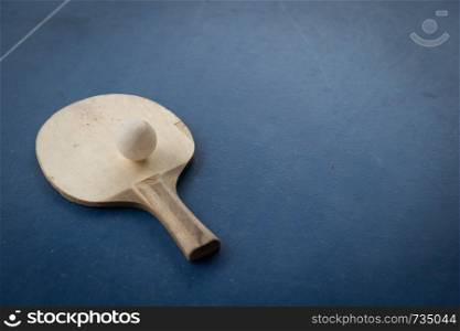 racket of table tennis with white ball