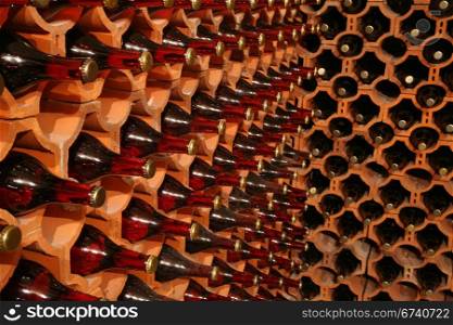 Racks with bottles in a dark wine cellar