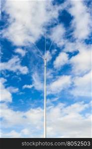 Radio antenna with five poles against blue cloud sky.