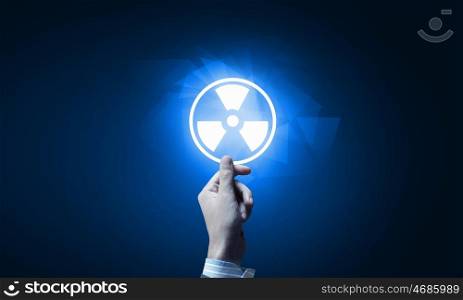 Radioactivity concept. Close up of human hand pushing application icon