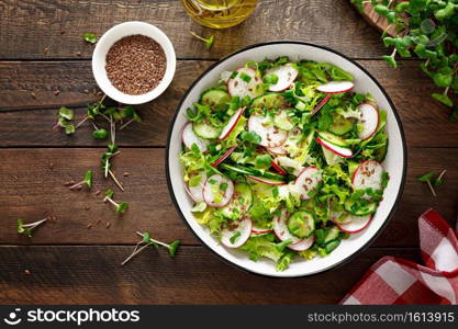 Radish and cucumber salad with fresh green onion in bowl, Top view