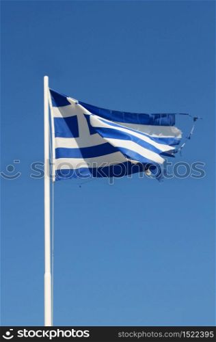 Ragged flag of Greece waving in wind vertical. Ragged Greek flag