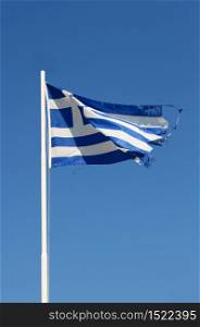 Ragged flag of Greece waving in wind vertical. Ragged Greek flag