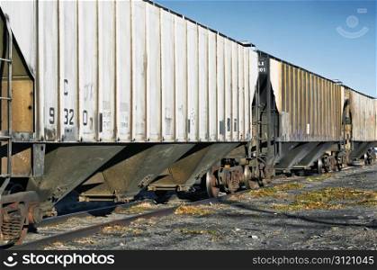 Railroad cars waiting on a siding to be loaded in a rural area