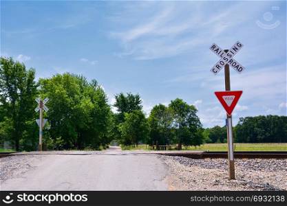 Railroad crossing sign against blue sky background, with space for your text.