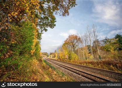 Railroad going through an autumn colored landscape with colorful trees in the fall