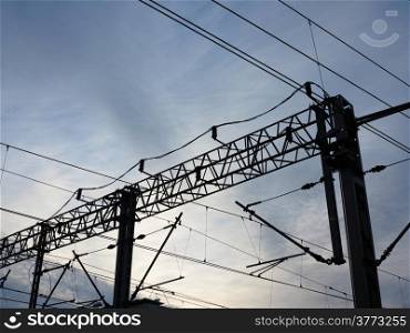 Railroad railway overhead power lines against blue sky. Contact wire.