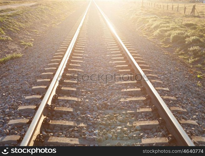 Railroad track sunlit with a beautiful sunset
