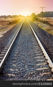 Railroad track sunlit with a beautiful sunset