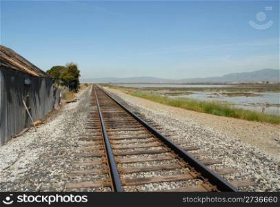 Railroad tracks and a tumbledown building, Alviso, California
