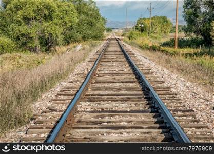 railroad tracks leading to distant foothills of Rocky Mountains in northern Colorado