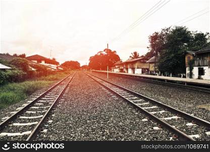 railroad tracks train leading from train station railway in countryside vintage old film style