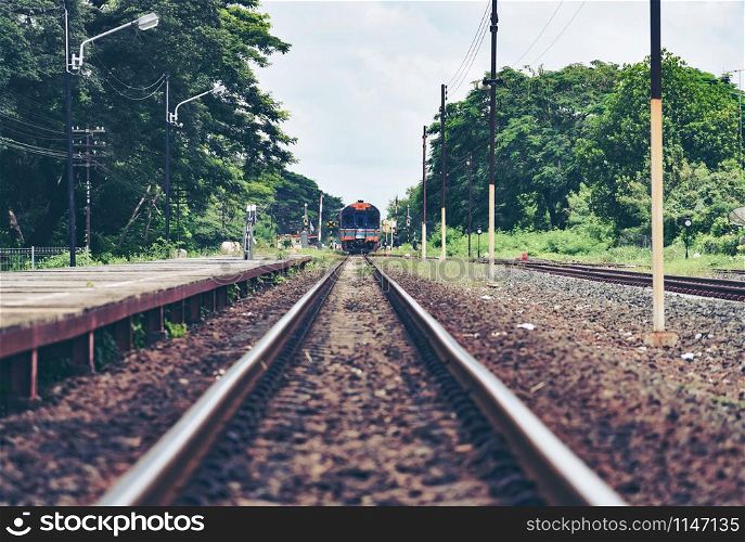 railroad tracks train leading from train station railway in countryside vintage old film style