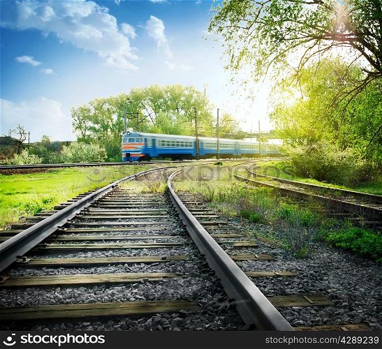 Railroad with train against the bright sun