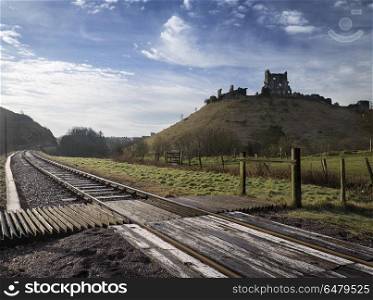 Railway runs around old Medieval castle ruins in countryside lan. Places. Railway track runs around old Medieval castle ruins in countryside landscape in England