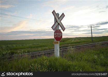 Railway sign and stop sign along roadway at Lake of the Woods, Ontario