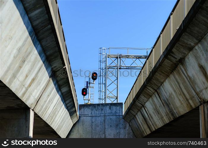 Railway signals between two dirty concrete bridges.