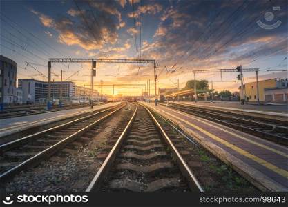 Railway station against beautiful colorful sky at sunset. Industrial landscape with railroad, blue sky with clouds in summer .Railway junction in the evening. Railway platfform. Transportation