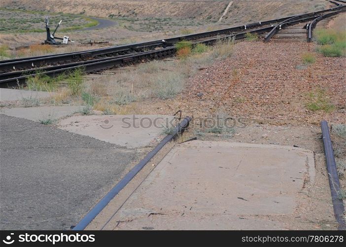 Railway switch, broken railroad track and motor road.