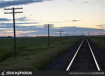 Railway tracks and hydro poles against twilight sky at Lake of the Woods, Ontario