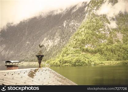 Rain and clouds on the Hallstattersee in Austria. Morning mist over the Austrian landscape with lake, forests, fields, pastures, meadows and wet roofs. Retro style