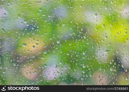 rain drop on window glass with blur tree in background