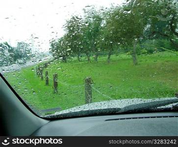 Rain drops on a blurry windshield.