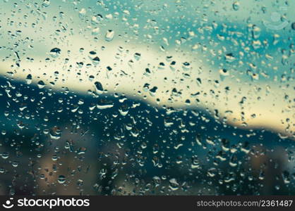 Rain drops on window glasses surface with sunset. drops on glass spray on window background for dark text selective focus