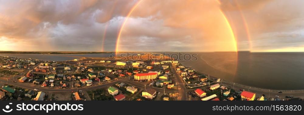 Rain falls as sun shines in the middle of the night at Kotzebue Alaska creating a beautiful contrast between the sunrise and storm
