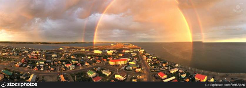Rain falls as sun shines in the middle of the night at Kotzebue Alaska creating a beautiful contrast between the sunrise and storm